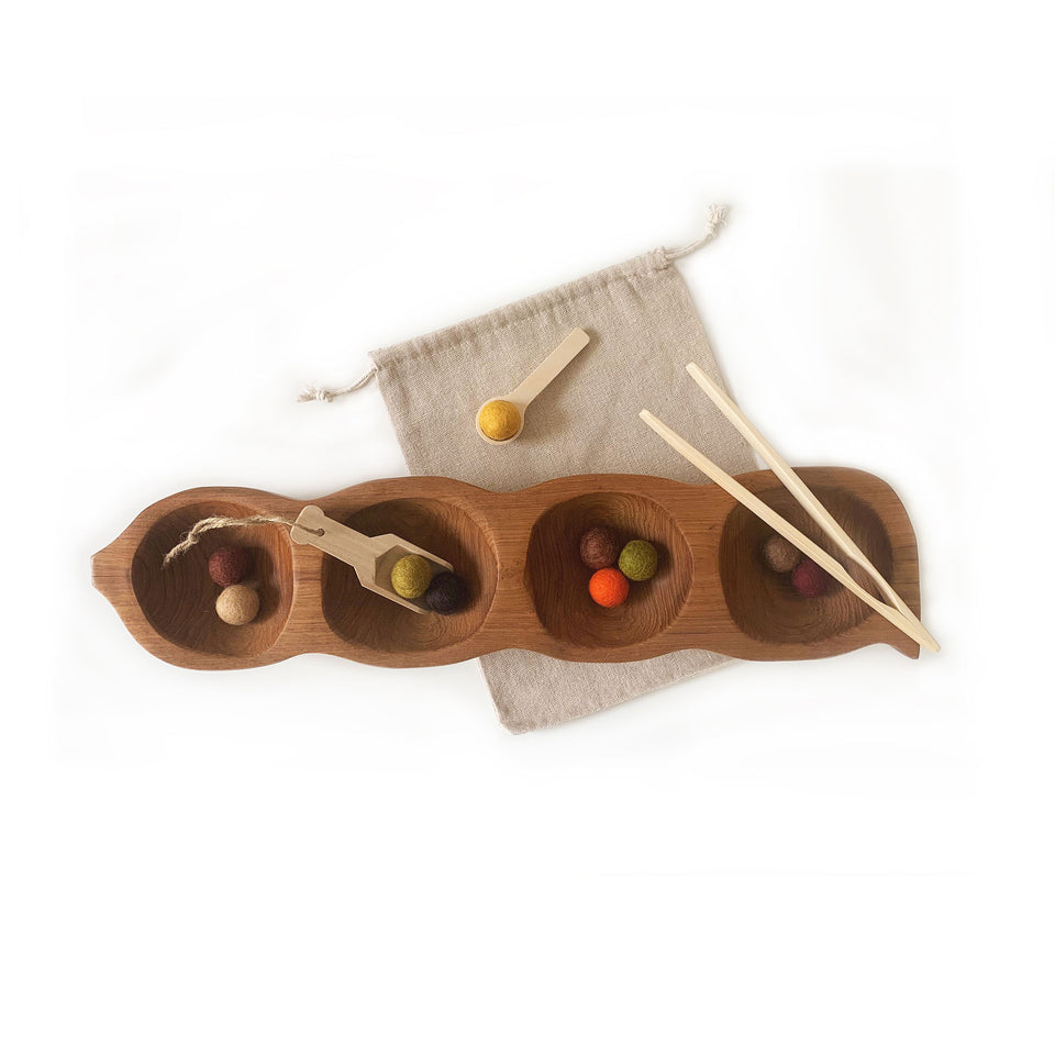 sensory play bundle which included natural coloured teak pea pod tray with bright felt balls, calico bag, wooden tongs, wooden scoop and small wooden spoon